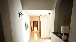 Un pasillo estrecho con suelo de baldosas que lleva a una puerta al final.