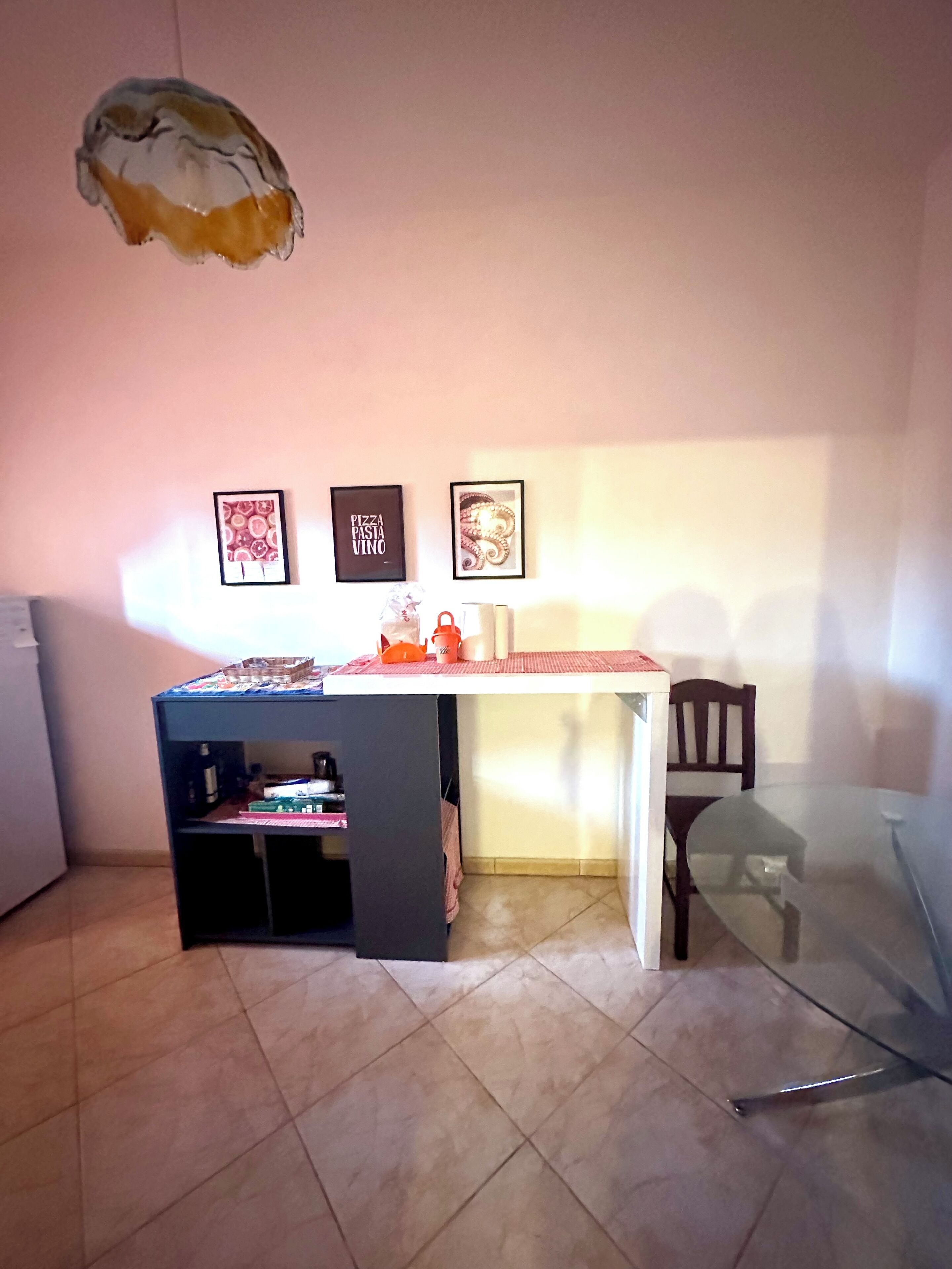 Un espace cuisine compact comprenant une table à manger, des chaises et un petit réfrigérateur.