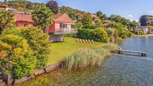 A residential area with houses, a body of water, and lush greenery. - Italian Lakes Lakeside Villa With Direct Lake Access (Ranco)