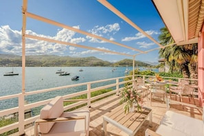 A terrace with a view of a lake and boats, furnished with chairs and tables. - Italian Lakes Lakeside Villa With Direct Lake Access (Ranco)
