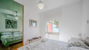 A bedroom with a bed, a bedside table, a mirror, and a window. - Italian Lakes Lakeside Villa With Direct Lake Access (Ranco)