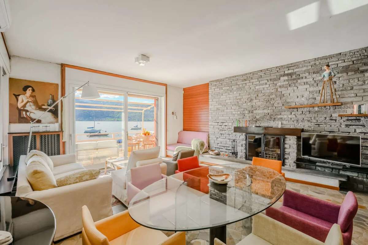 Uma sala de estar moderna com lareira, assentos confortáveis e uma grande janela com vista panorâmica.