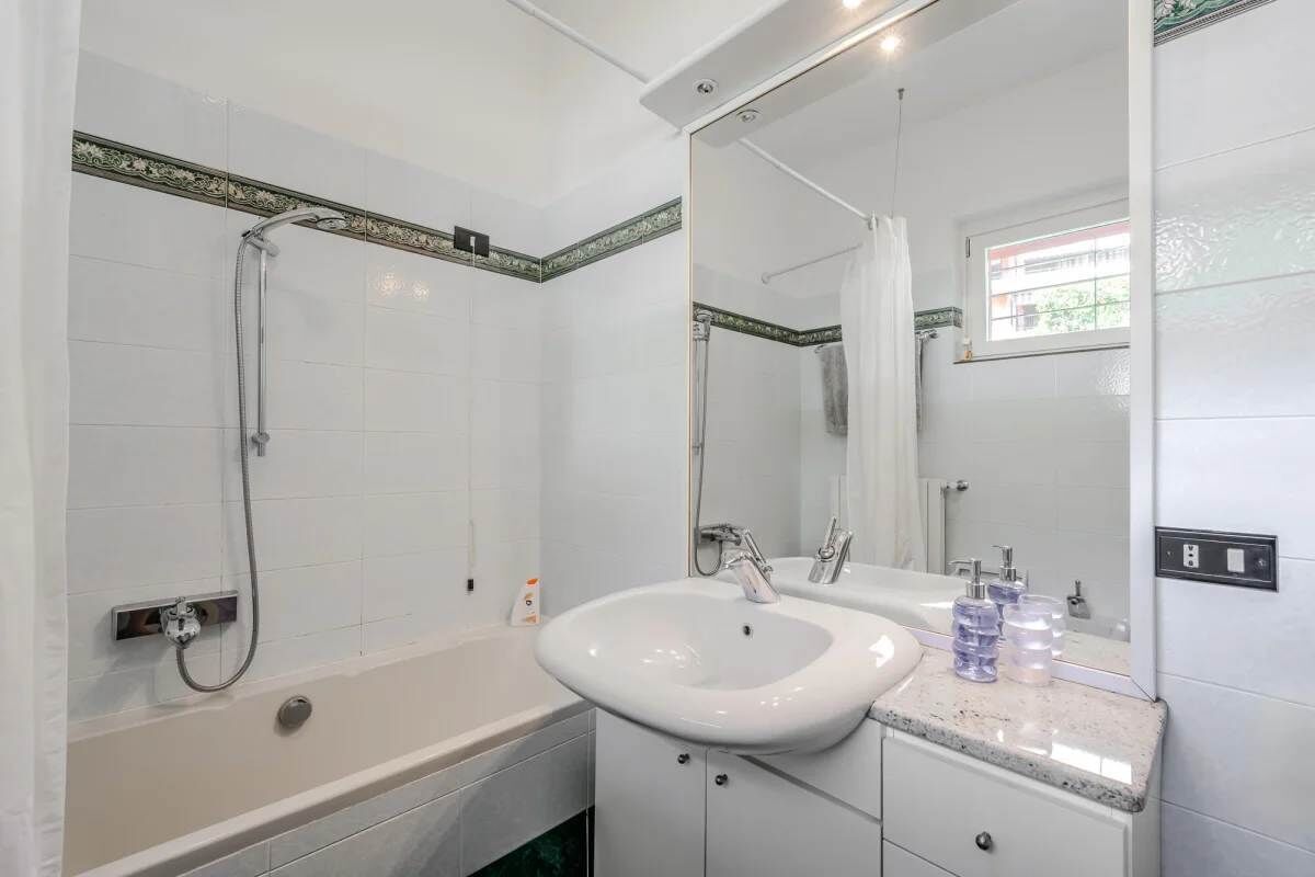 Un baño con bañera, lavabo y espejo.
