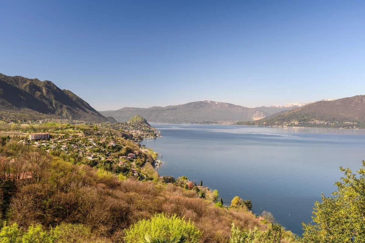A lake with a town on the shore, surrounded by hills.