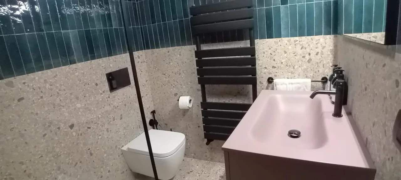 A bathroom with a white toilet, a sink with a faucet, and a towel rack.