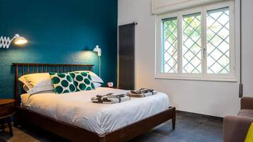 A bedroom with a bed, a window, and a nightstand.