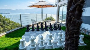 A chessboard set up on a terrace with a view of the sea and mountains. - Pallanza Villas (Verbania)