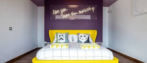 A bedroom with a bed, a neon sign, and a chandelier.