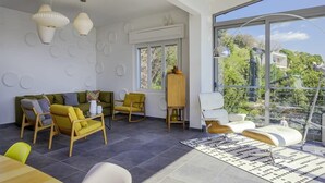 A modern living room with a large window, a sofa, chairs, and a coffee table. - Pallanza Villas (Verbania)