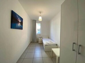 Ein Schlafzimmer mit einem Bett, einem Nachttisch und einem Bild an der Wand.