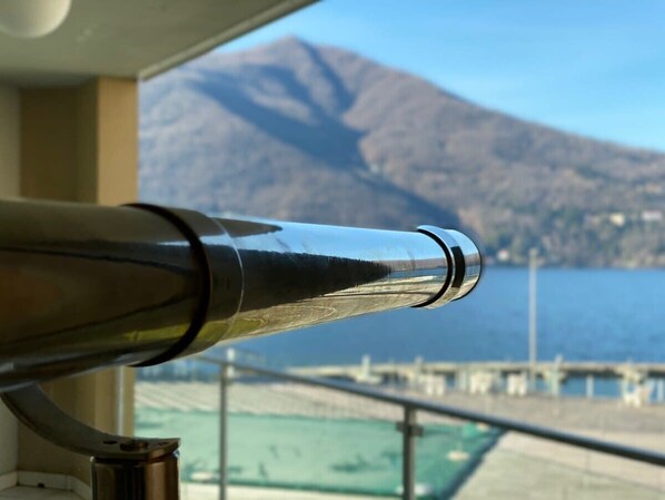 A telescope with a view of a mountain and a body of water. - Maccagno Apartments (Maccagno con Pino e Veddasca)