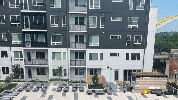A rooftop pool area with lounge chairs and a wooden deck. - The 513 Flat! Pool & River View! Free Gated Parking! Walk to Banks & Stadiums! (Cincinnati)