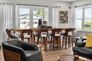 Relax in this stylish living area with a central bar, black leather sofa, and comfortable armchair.