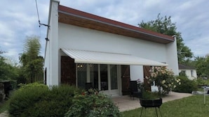 Una casa moderna con fachada blanca, techo de madera y un porche cubierto.