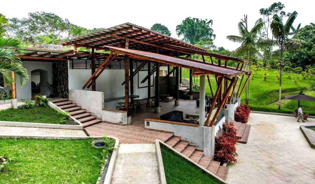 Een moderne buitenconstructie met een houten pergola, betonnen trappen en een terras.