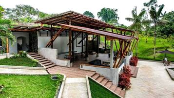 Een moderne buitenconstructie met een houten pergola, betonnen trappen en een terras.