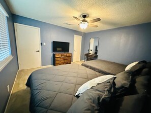 A bedroom with a bed, a dresser, a TV, and a ceiling fan. - #3 Charming 4BR 2BA Home in Midland – Comfort, Convenience & Great Location! (Midland)