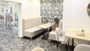 A modern interior with a sofa, chairs, a table, and a patterned wall. - SAAFI Boutique Hotel (Abuja)