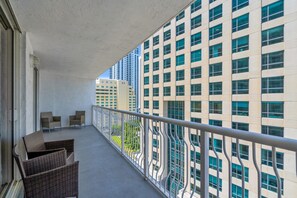 A balcony with wicker furniture and a view of a high-rise building. - Relaxing 1-Bed Condo W/ City Views in Brickell Key (Miami)