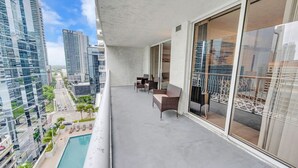 A balcony with a pool, modern furniture, and a city view. - Elegant 1 BR Retreat in Brickell W/ Free Parking (Miami)