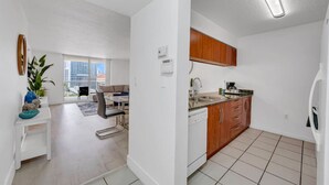 A modern apartment with a kitchen, dining area, and a balcony with a city view. - Elegant 1 BR Retreat in Brickell W/ Free Parking (Miami)