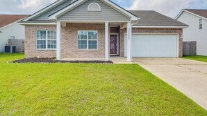 A single-story house with a brick facade, a front porch, and a garage. - A Getaway on the Gulf Coast for the whole family! (Gulfport)