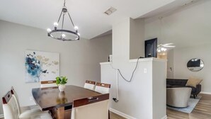 A modern living room with a dining area, a TV, and a ceiling fan. - A Getaway on the Gulf Coast for the whole family! (Gulfport)