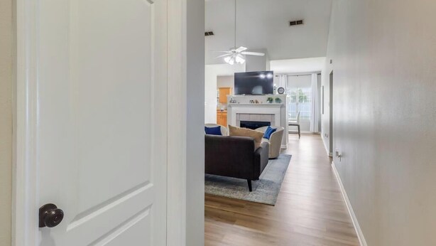 A modern living room with a fireplace, a television, and a ceiling fan. - A Getaway on the Gulf Coast for the whole family! (Gulfport)