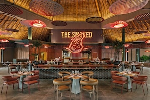 A restaurant with a high ceiling, red hanging lamps, and a neon sign reading 'THE SMOKED.' - Bahia Principe Escape Tequila - Adults Only All Inclusive - Brand New Hotel (Akumal)