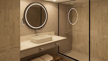 Un baño moderno con un espejo grande, un lavabo rectangular y una cabina de ducha de vidrio.