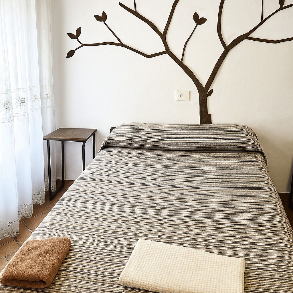 Une chambre à coucher avec un lit, une petite table et un élément de décoration murale.