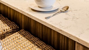A modern kitchen with a marble countertop, a bowl of fruit, a Bosch dishwasher, and a microwave. - Mountain View Cape Town Apt City Suite 1614 (Cape Town)