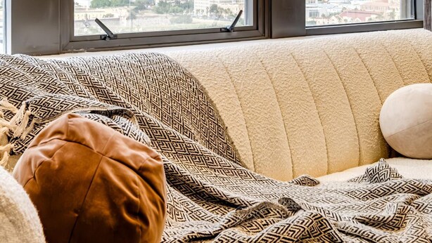 A room with a large window offering a view of a mountainous landscape and a city below. - Mountain View Cape Town Apt City Suite 1614 (Cape Town)