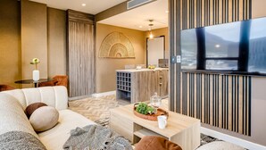 A modern living room with a sofa, coffee table, and a TV mounted on the wall. - Mountain View Cape Town Apt City Suite 1614 (Cape Town)