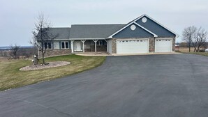 A two-story house with a garage, a covered porch, and a landscaped driveway.