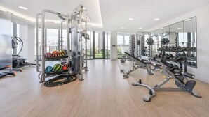 A modern gym with cardio machines, weightlifting equipment, and a variety of exercise balls.