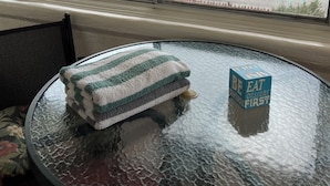 A room with a large window overlooking a residential area, a round glass table with a towel and a cube-shaped object on it. - 2 Bedroom Suite in beautiful Ensenada with a jacuzzi in the room. Ocean view! (Ensenada)
