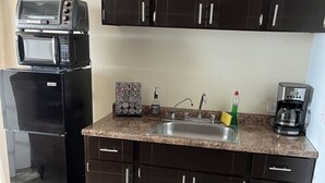 A compact kitchen with dark cabinets, a microwave, a coffee maker, and a sink. - 2 Bedroom Suite in beautiful Ensenada with a jacuzzi in the room. Ocean view! (Ensenada)