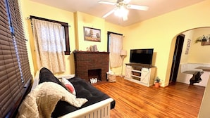 A cozy living room with a fireplace, a television, and a comfortable seating area. - Charming 2-bedroom apartment in beautiful Belleville with WiFi (Belleville)