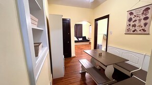 A compact kitchen with a wooden bench and a dining table, a ceiling fan, and a wall-mounted poster. - Charming 2-bedroom apartment in beautiful Belleville with WiFi (Belleville)