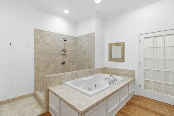 A bathroom with a large bathtub, a shower, and a toilet.