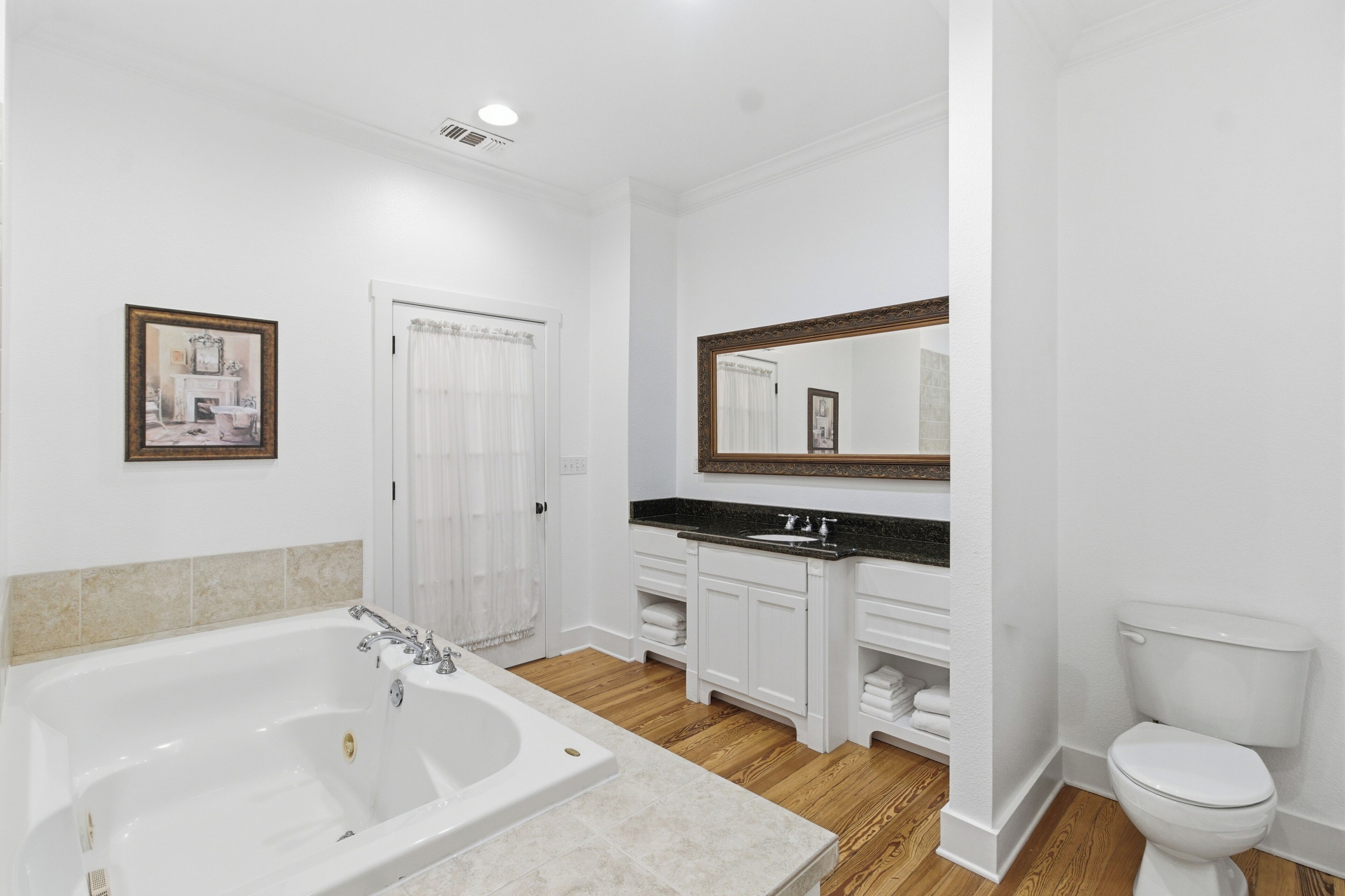 Un baño con bañera, lavabo, inodoro y espejo.