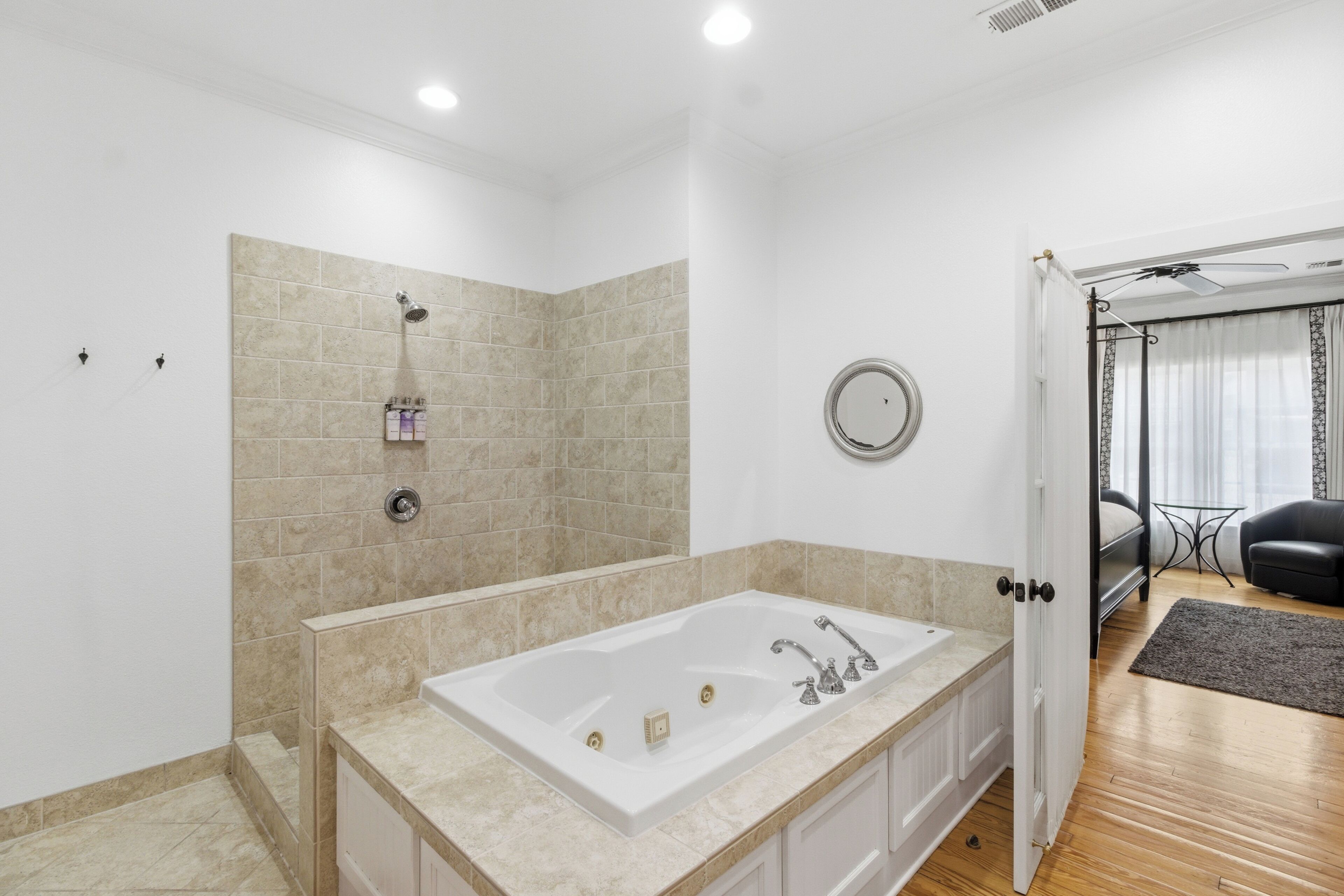 A modern bathroom with a large bathtub, a shower, and a mirror on the wall.
