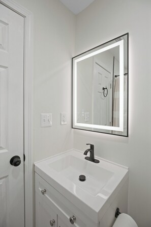 A bathroom with a white sink, a mirror, and a toilet. - Located in the heart of SE Washington, DC. Perfect for both short /long stays. (Washington)