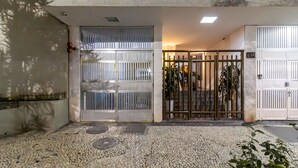 A building entrance with a tiled pavement, a metal gate, and a white wall. - 3 Minutes From Leme Beach Gs1102 (Rio de Janeiro)