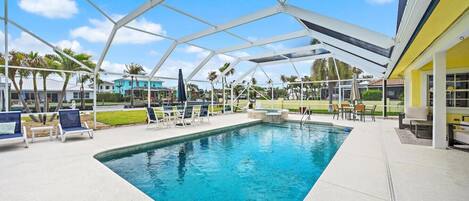 A swimming pool with a covered area, lounge chairs, and a view of the surrounding landscape.