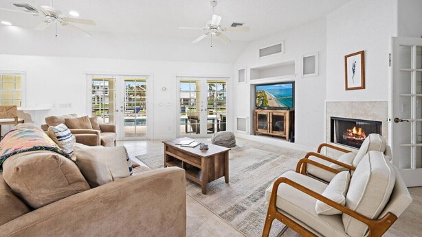 A spacious living room with a fireplace, comfortable seating, and a television.