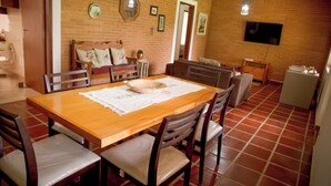 Un coin repas avec une table en bois, des chaises et un mur en briques.