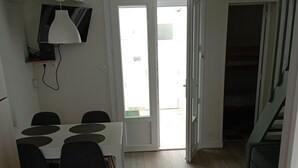 Ett kompakt bostadsutrymme med en matplats, en trappa och en soffa.