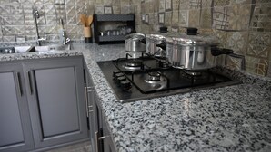 A kitchen with granite countertops, stainless steel appliances, and patterned backsplash tiles.